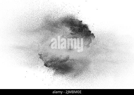 Black powder explosion on white background.Black dust particles splash. Stock Photo