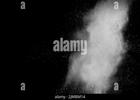 Bizarre forms of white powder explosion cloud against black background.White dust splash. Stock Photo