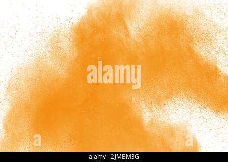 Abstract explosion of orange dust on white background. Freeze motion of orange powder splashing. Stock Photo