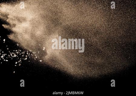 Dry river sand explosion. Golden colored sand splash against  black background. Stock Photo