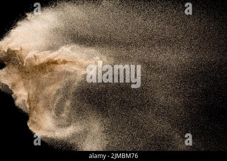Dry river sand explosion. Golden colored sand splash against  black background. Stock Photo