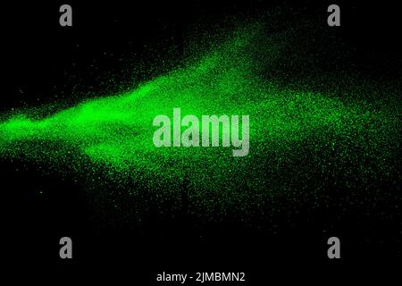 Green color powder explosion cloud  on black background.Green dust splash on dark background. Stock Photo