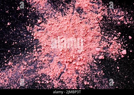 Pink color background of chalk powder. Pink color dust particles splattered on black background. Stock Photo