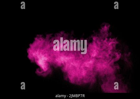 Pink powder explosion on black background.Pink dust splash cloud on dark background. Stock Photo