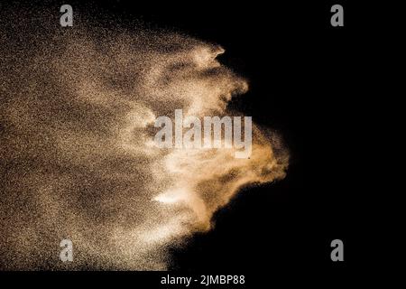 Golden sand explosion isolated on black background. Abstract sand cloud. Golden colored sand splash Stock Photo
