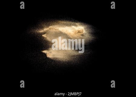 Golden sand explosion isolated on black background. Abstract sand cloud. Golden colored sand splash Stock Photo
