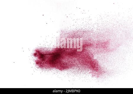 Abstract red dust splattered on white background. Red powder explosion.Freeze motion of red particle Stock Photo
