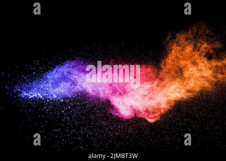 Abstract multi color powder explosion on black background.  Freeze motion of color dust  particles. Stock Photo