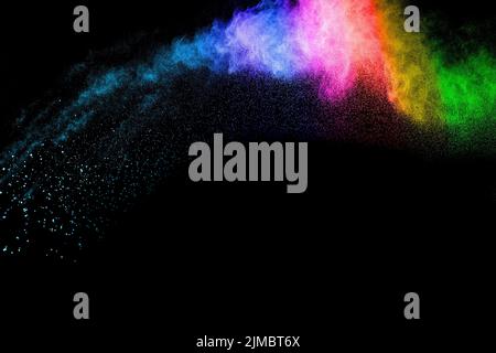 Abstract color powder explosion on black background.Freeze motion of dust splash. Stock Photo