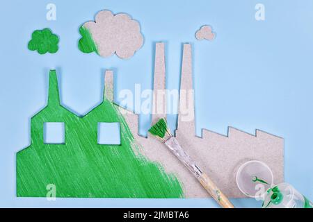 Greenwashing concept with cardboard factory being painted green Stock Photo