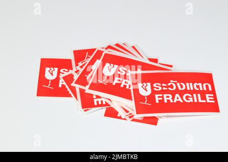 red Fragile stickers for stick on a parcel with thai language mean 'Handle with care' isolated on white background. Stock Photo