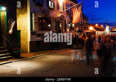 At night, visitors crowd the area in Bowens Wharf in Newport Rhode Island, an area with shops, cafes and restaurants Stock Photo