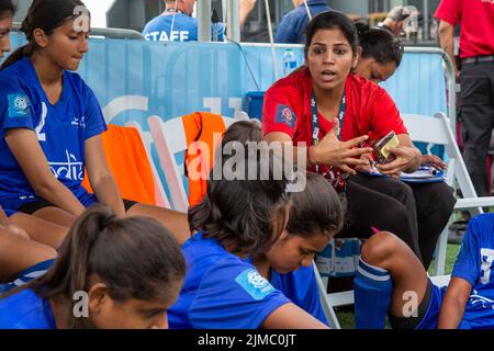 Detroit, Michigan - The women's teams of India and Namibia meet in the Special Olympics Unified Cup football (soccer) tournament. A coach talks to Ind Stock Photo