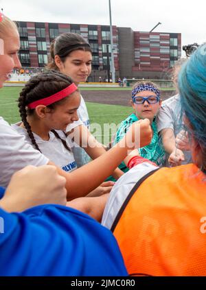 Detroit, Michigan - Players on the United States women's team in the Special Olympics Unified Cup football (soccer) tournament huddle before their mat Stock Photo