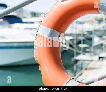 Life buoy hung on a railing in the port. Stock Photo