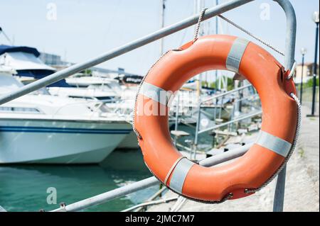 Life buoy hung on a railing in the port. Stock Photo