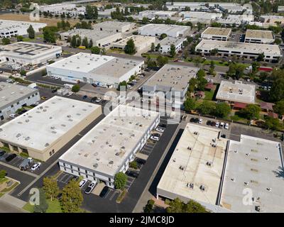 Nondescript warehouse and industrial office buildings are shown during the afternoon from an aerial view. Stock Photo