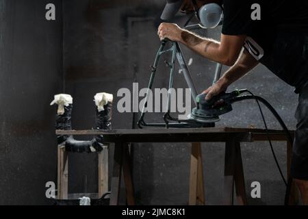 man working on a steel bicycle frame Stock Photo