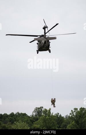 Infantrymen with Company B. 1st Battalion 151st Infantry Regiment alongside cavalry scouts and mortarmen conduct urban training at Muscatatuck Urban Training Center, Ind., Tuesday, Aug. 2, 2022. A Black Hawk rescues a mock casualty as part of a medical evacuation exercise. Participating in realistic training scenarios is how the Indiana National Guard maintains a lethal fighting force. Stock Photo