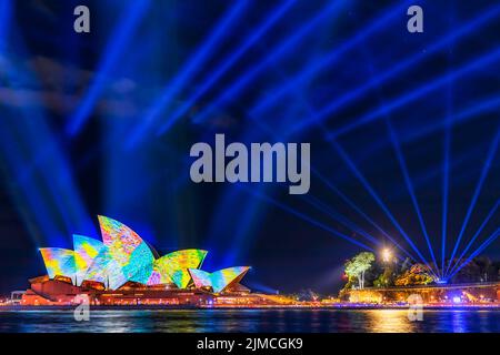 Sydney, Australia - 1 June 2022: Sydney opera house under blue laser beams with projected images and footages of light during Vivid Sydney light show Stock Photo