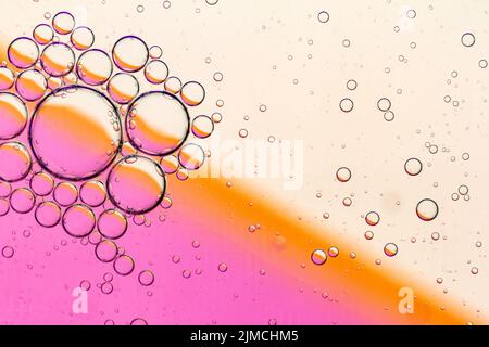 Abstract Background of Oil Bubbles on Water Surface pink salmon colorful palette. Stock Photo