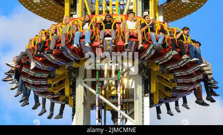 Crange, Herne, NRW, 05th Aug, 2022. People on the 85 metre high 'Hangover - The Tower' ride. The official opening day of the 2022 Cranger Kirmes, Germany's 3rd largest funfair and the largest of its kind in NRW, sees thousands of visitors enjoying the carousels, roller coasters, beer halls, food stalls and other attractions. The popular fair, which was paused during the pandemic, regularly attracts more than 4m visitors during its 10 day run and has been established for decades in its current form, with the fair itself dating back to the early 18th century at Crange. Credit: Imageplotter/Alamy Stock Photo