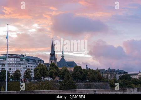 Scenic cityscape with typical aged residential buildings located on street against picturesque cloudy sunset sky in Luxembourg