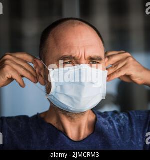 Man wearing facial disposable mask. Virus protection Stock Photo