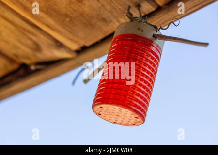 Red cylindrical light hanging from a ceiling Stock Photo