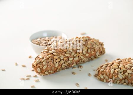 High angle of loaves of fresh yummy sunflower seed bread placed on white background in bakery Stock Photo
