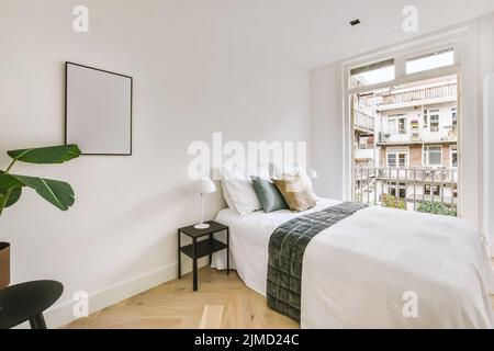 modern white and lighted bedroom with big bed and minimal decoration and furniture Stock Photo