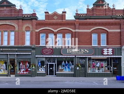 Old fashioned small town main street stores in ornate brick building Stock Photo