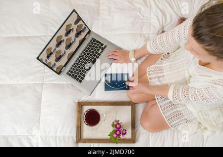 Great concept of vacation planning, woman planning the holidays, passport in hand, computer, legs cr Stock Photo