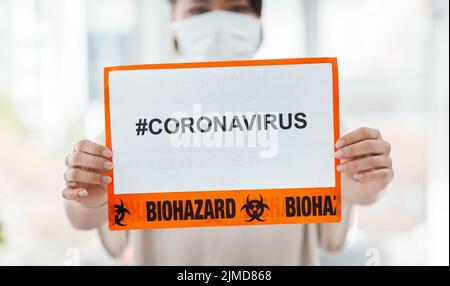 Spread hashtags not viruses. a woman holding up a sign with CORONAVIRUS on it. Stock Photo