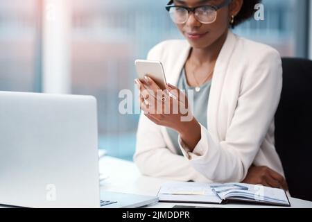Business woman with a phone texting, browsing and searching social media while working in the office. Creative agent checking schedule list Stock Photo