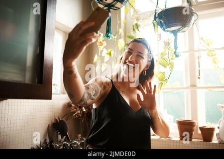 Talking on phone video call, waving and greeting while communicating, chatting and networking during lockdown. Smiling, happy and cheerful woman or Stock Photo