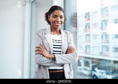 Confident manager, leader and creative boss with her arms crossed in a powerful, assertive and proud stance. Portrait of smiling, happy and female Stock Photo