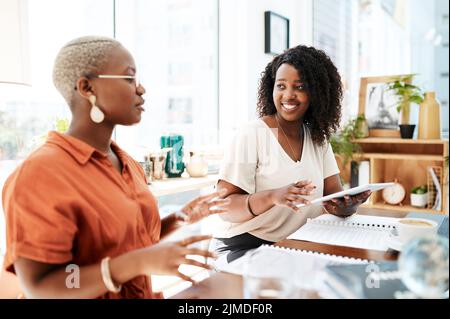 They have a shared passion for what they do. two businesswomen having a discussion in an office. Stock Photo