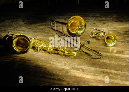 Brass and wind instruments - saxophone, trombone, trumpet on stage with backlight Stock Photo