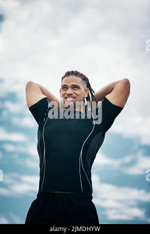 Get ready for this. a handsome young rugby player throwing a ball while training on the field. Stock Photo