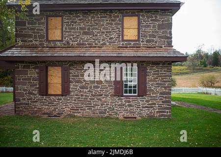 Colonial American house with broken boarded up windows Stock Photo