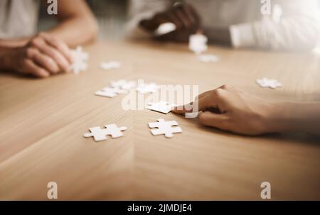 Business people brainstorming solution, problem solving and showing teamwork, working together on puzzle pieces. Team or smart business group activity Stock Photo