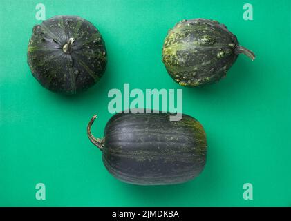 Green Autumn Pumpkins On Green Paper Background Stock Photo