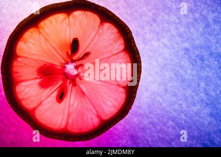 Lemon thin slice, macro capture, colorfully illuminated and back lit Stock Photo
