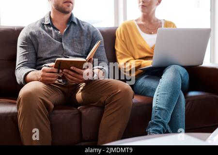 Sharing ideas to ensure they reach success together. Closeup shot of two unrecognisable businesspeople having a discussion while sitting on a couch in Stock Photo