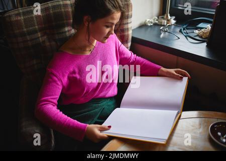 Pretty young woman reading menu in cafe Stock Photo