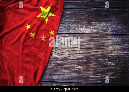 Chinese flag on rustic wooden background for Martyrs Day, China National Day or Labor Day concept. Stock Photo
