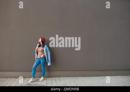 Charming young lady posing near grey wall Stock Photo