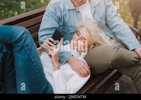 Young couple in love enjoying their date, using mobile phone Stock Photo