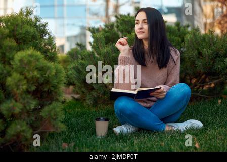 Pretty young lady studying outdoors in the park Stock Photo